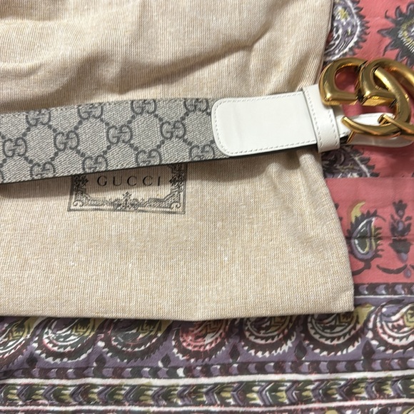 Tan gucci belt, with gold gucci sign, and black and brown gucci imprint on it. - Picture 5 of 11